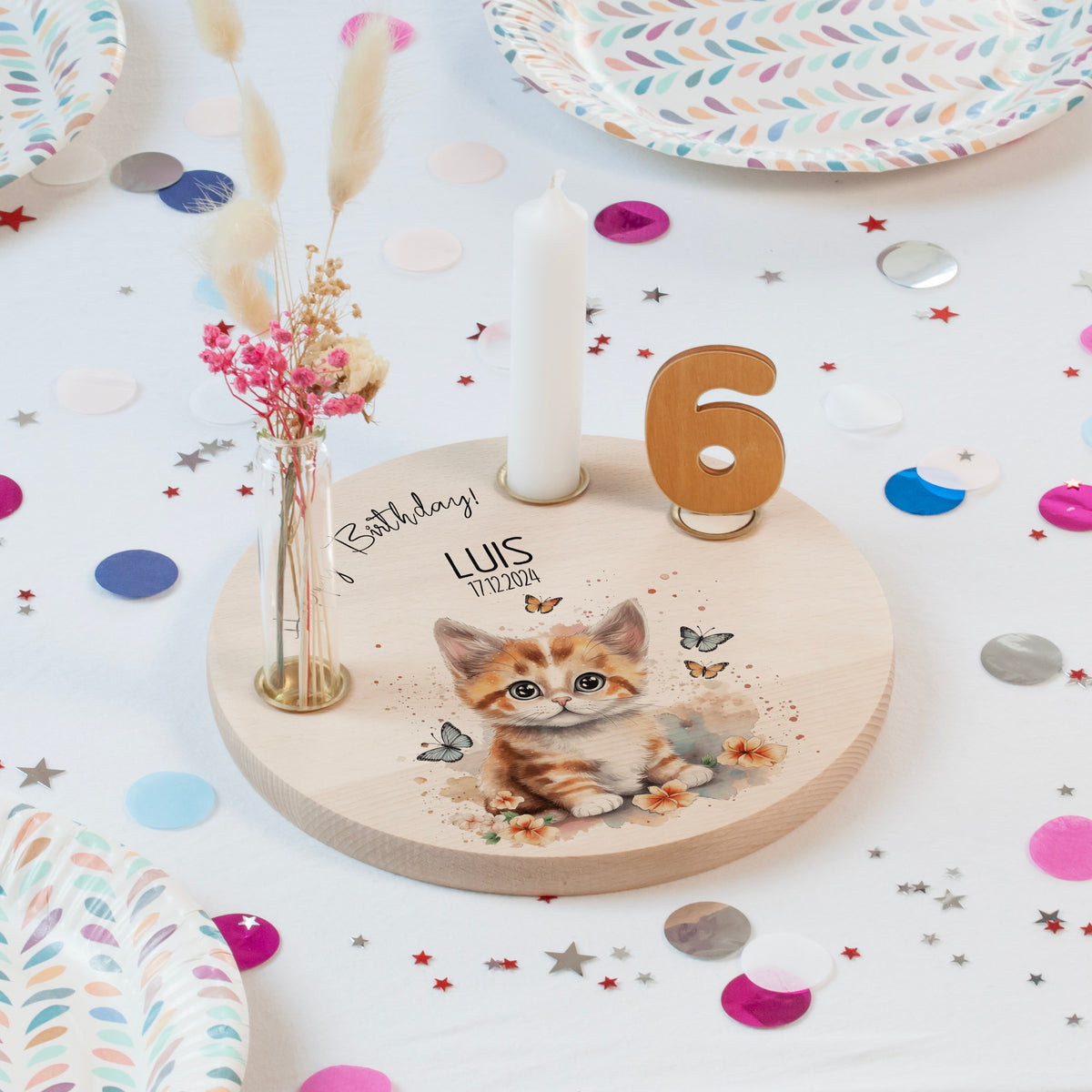 Personalisierter Geburtstagsteller (Katze) mit Kerze und Vase auf dekoriertem Geburtstagstisch